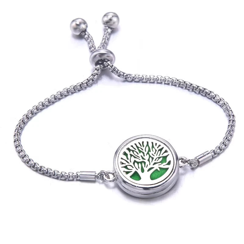 Silver bracelet with a green pad featuring a tree design on a white background