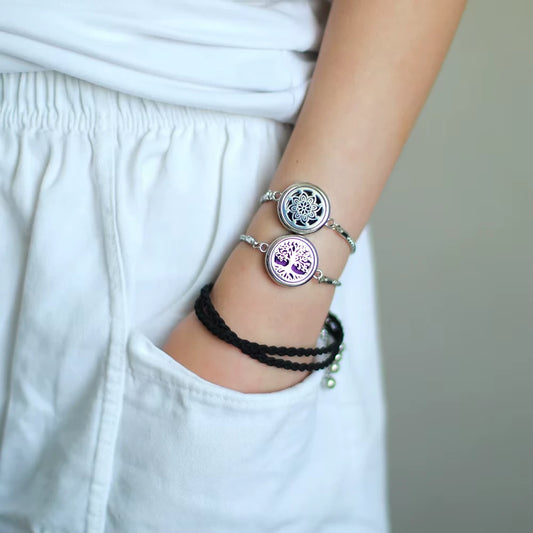 Close-up of a person's wrist wearing multiple bracelets with a neutral background
