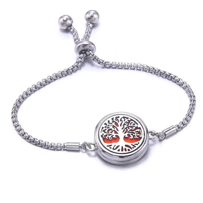 Silver bracelet with a orange pad featuring a tree of life design on a white background