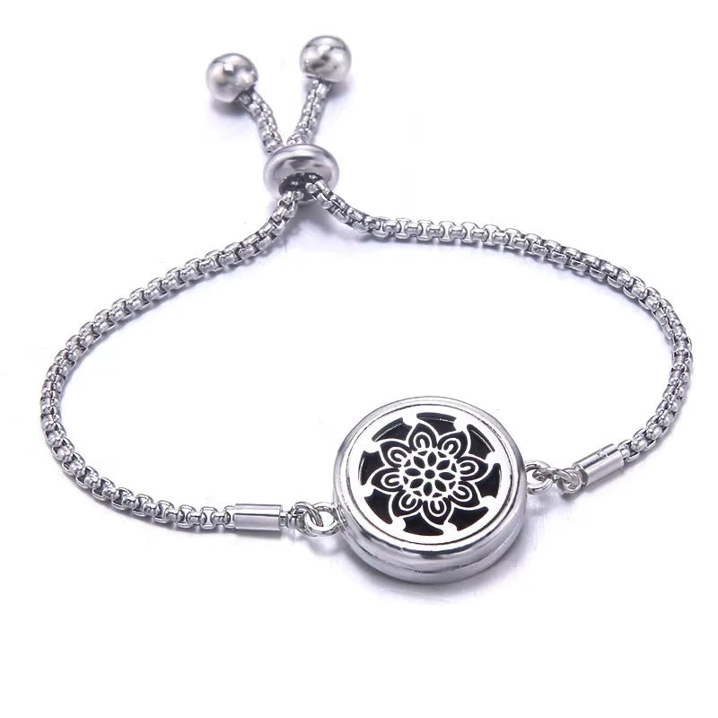 Silver bracelet with a black pad featuring a floral design on a white background