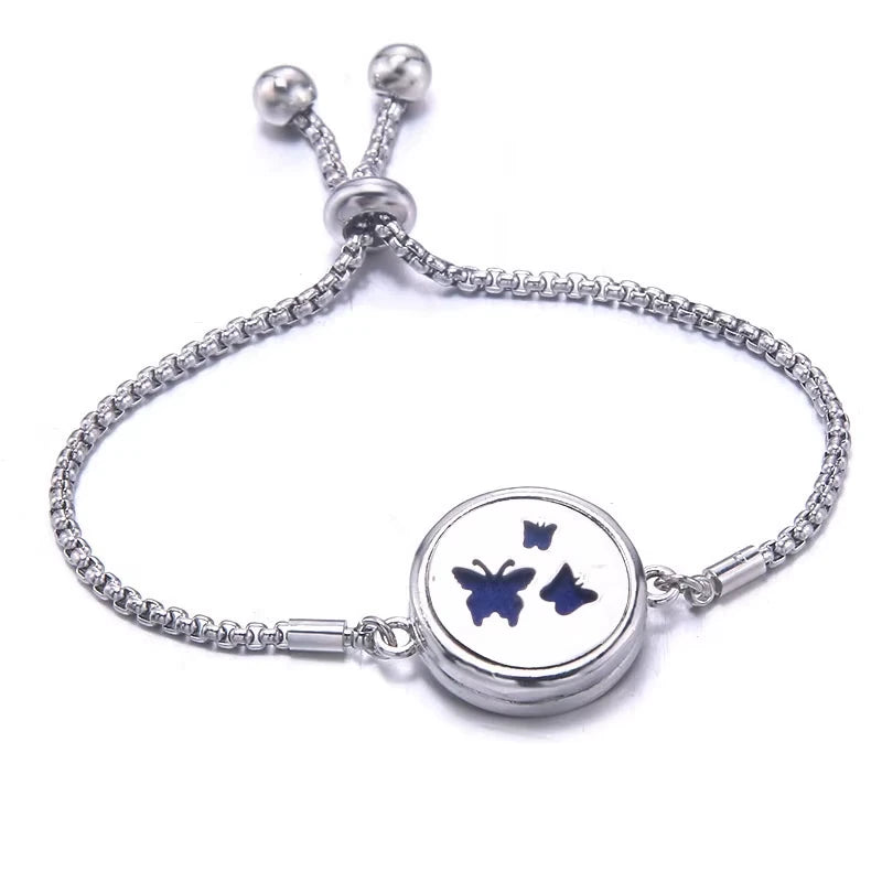 Silver bracelet with a blue pad featuring a three butterfly design on a white background