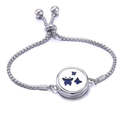 Silver bracelet with a blue pad featuring a three butterfly design on a white background