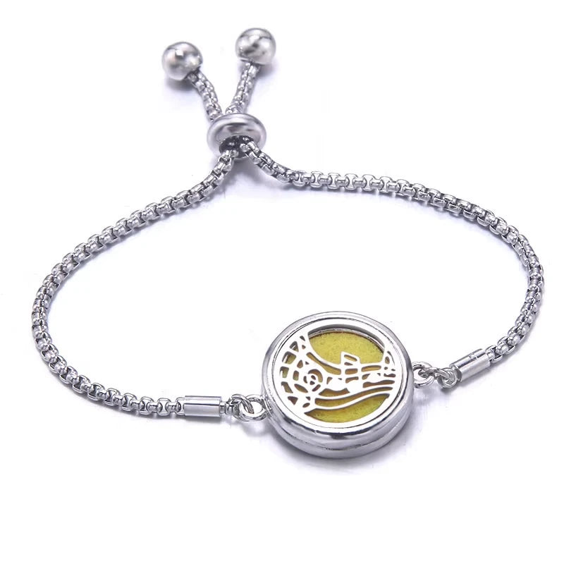 Silver bracelet with a yellow pad featuring musical notes design on a white background
