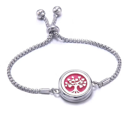 Silver bracelet with a pink pad featuring tree-of-life design on a white background