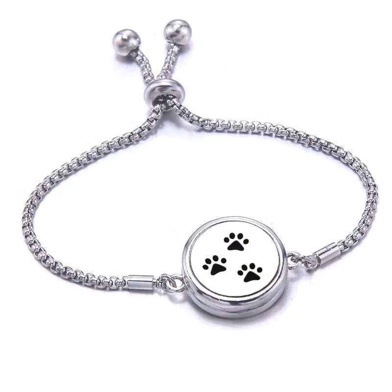 Silver bracelet with paw print design on a white background