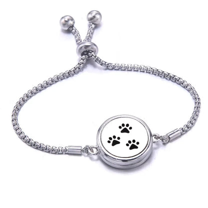 Silver bracelet with paw print design on a white background