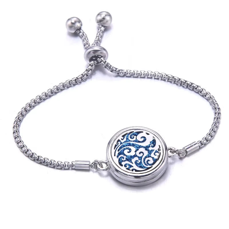 Silver bracelet with a blue pad featuring a scroll design on a white background