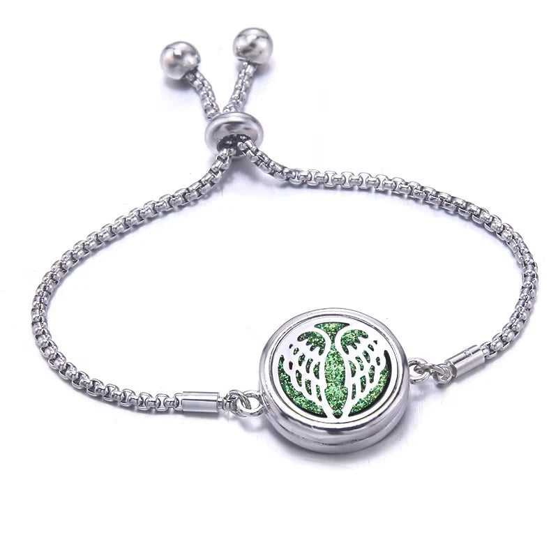 Silver bracelet with a green pad and angel wing design on a white background