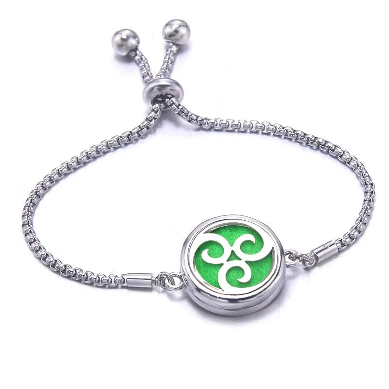 Silver bracelet with a green pad featuring a wave design on a white background