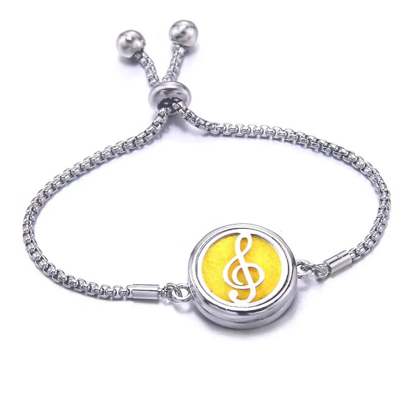 Silver bracelet with a yellow pad featuring a treble clef symbol on a white background