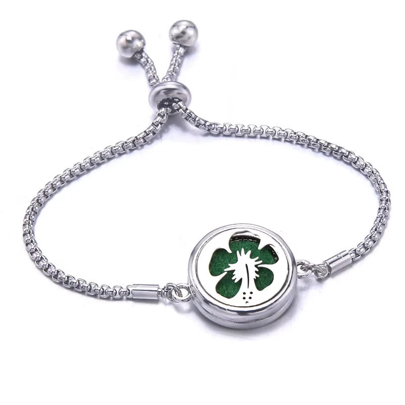 Silver bracelet with a green pad featuring a hibiscus design on a white background