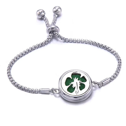 Silver bracelet with a green pad featuring a hibiscus design on a white background