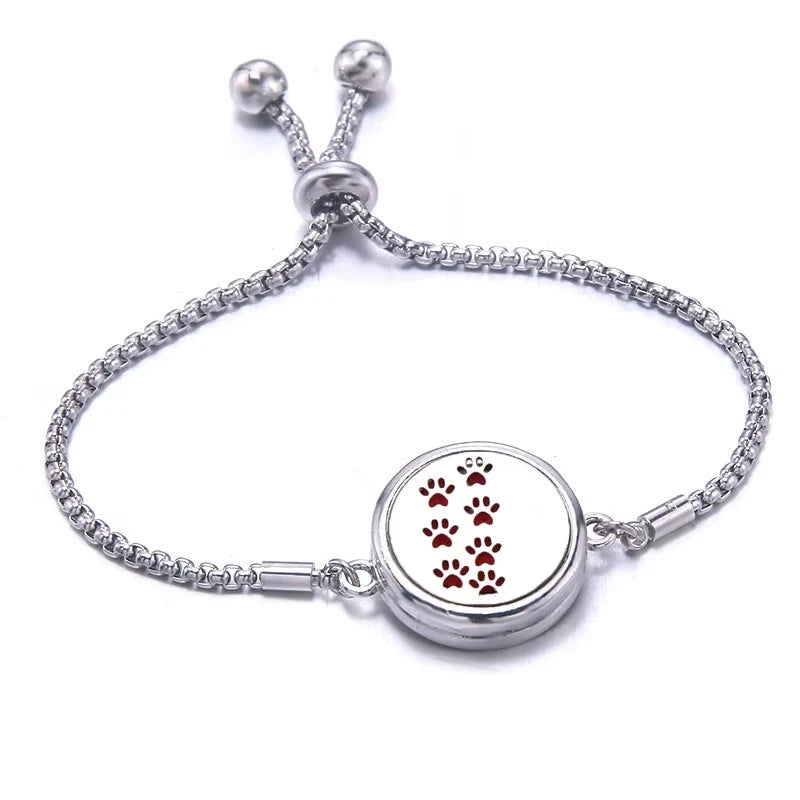 Silver bracelet with a red pad featuring paw prints on a white background
