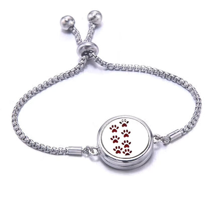Silver bracelet with a red pad featuring paw prints on a white background
