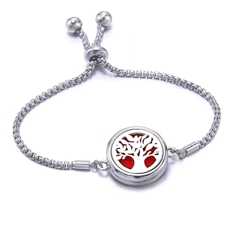 Silver bracelet with a red pad featuring a tree design on a white background