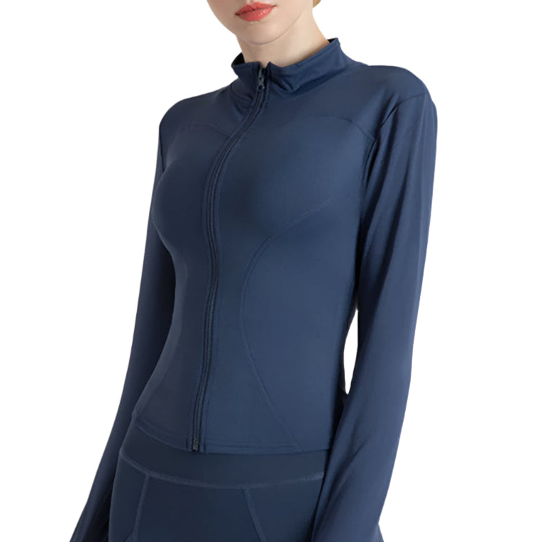 Woman wearing a blue zip up thumb hole jacket and blue leggings showing the front view against a white background 