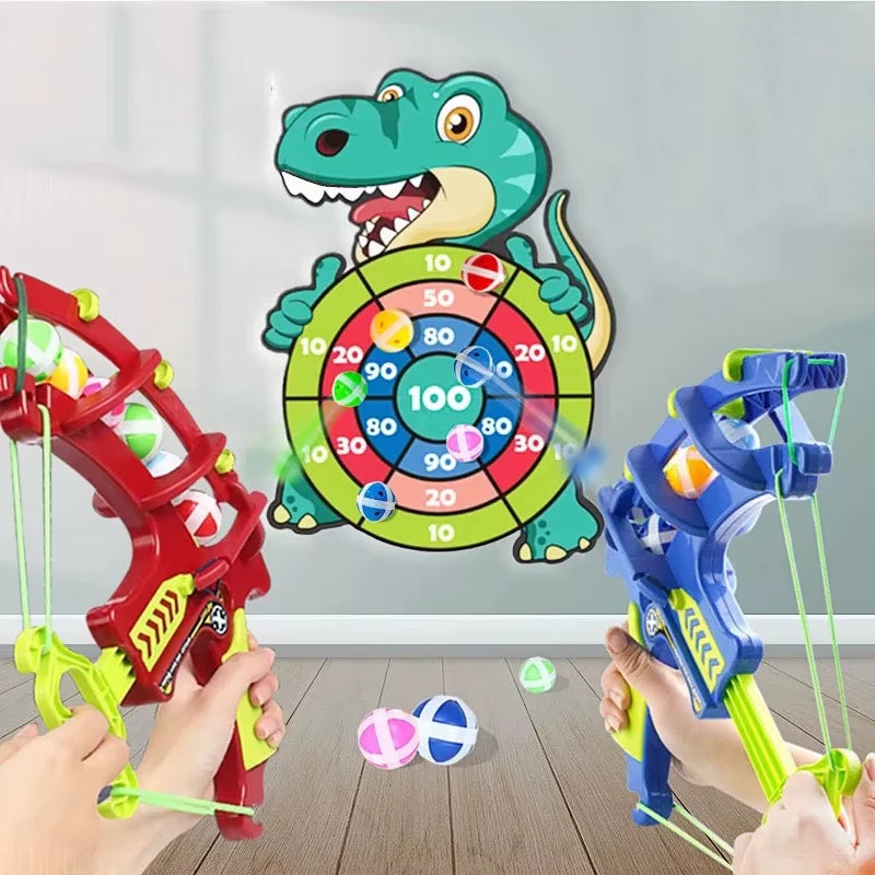 Two Bows  being used to aim and launch sticky balls at a crocodile-shaped target board mounted on a wall.