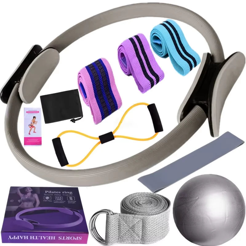Set of Grey exercise equipment including a Pilates ring, resistance bands, and a ball on a white background.
