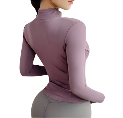 Woman wearing a purple zip up thumb hole jacket and gray leggings showing the back against a white background
