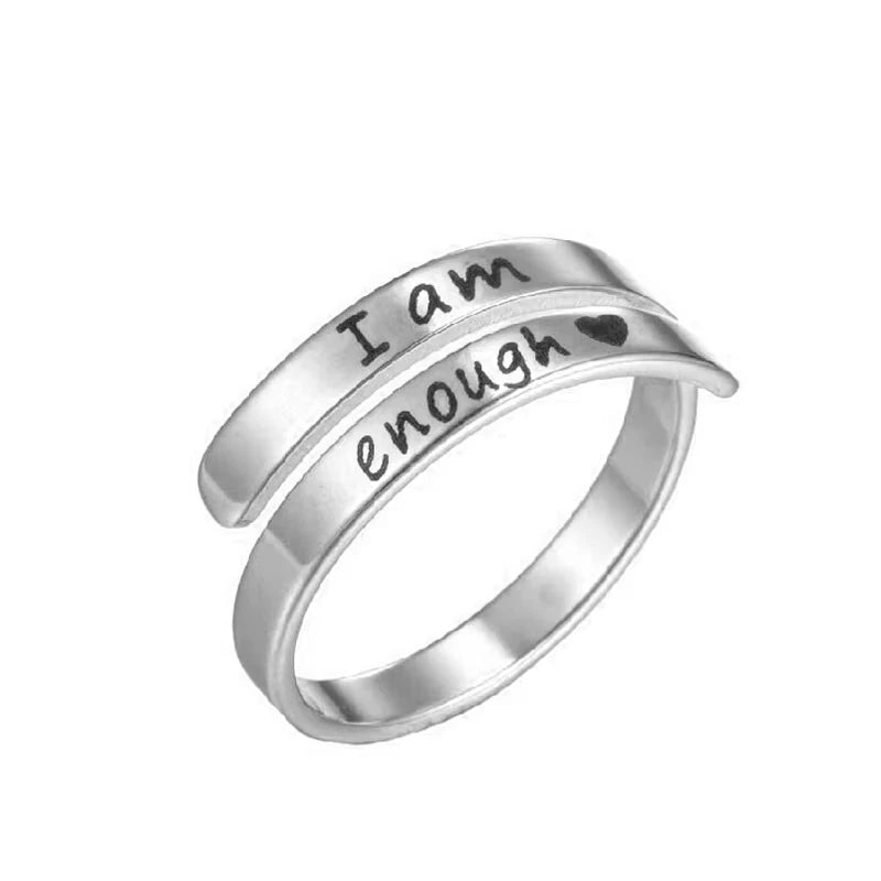 Silver ring with 'I am enough' laser etched on, on a white background