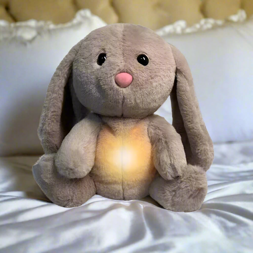SnugglePal bunny  with glowing belly on a bed