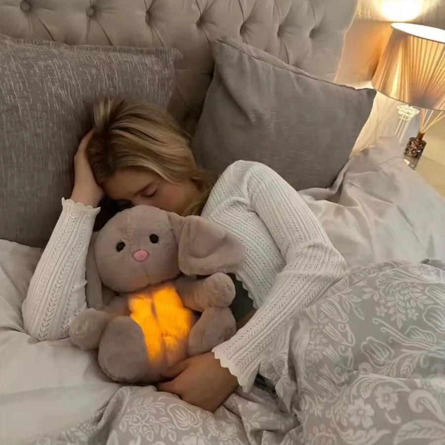 girl holding a glowing SnugglePal in bed