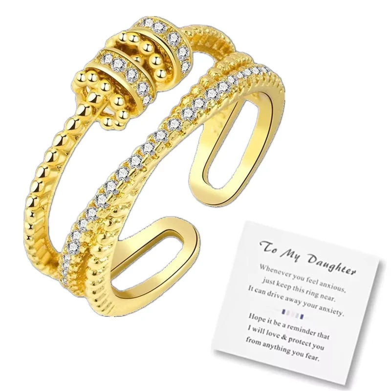 Gold ring with spinner accents and a message card on a white background