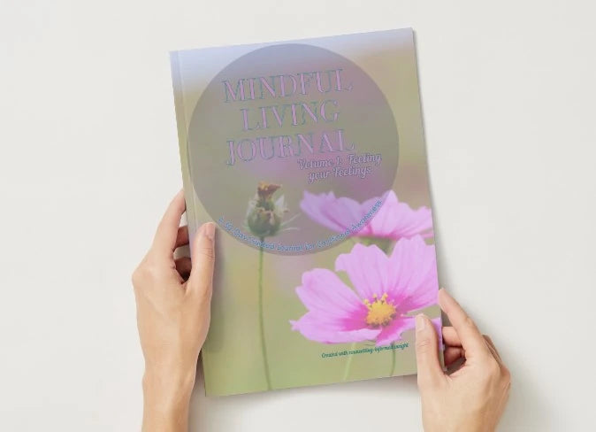 Book titled 'Mindful Living Journal' held by hands on a light background