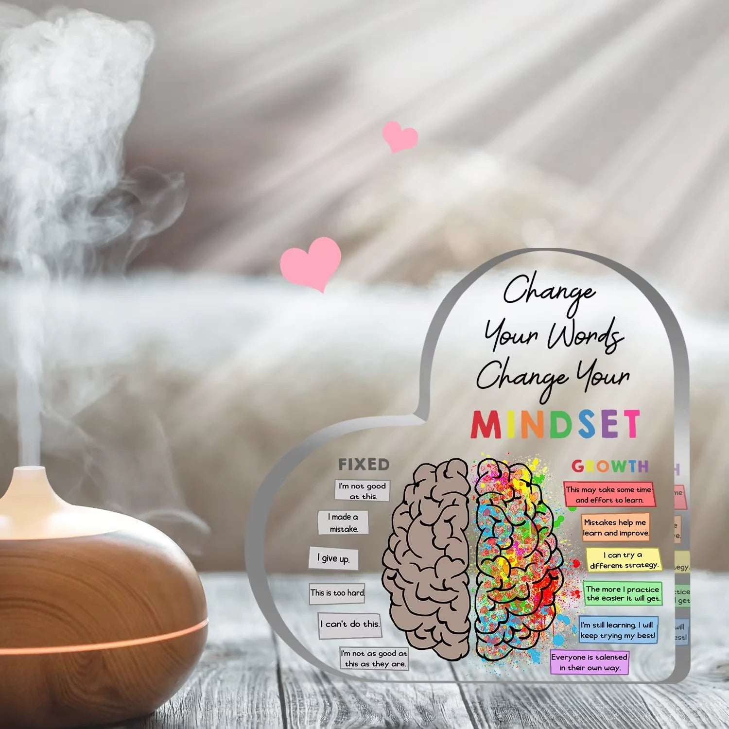 Decorative acrylic with brain illustration and motivational phrases next to a diffuser with steam.