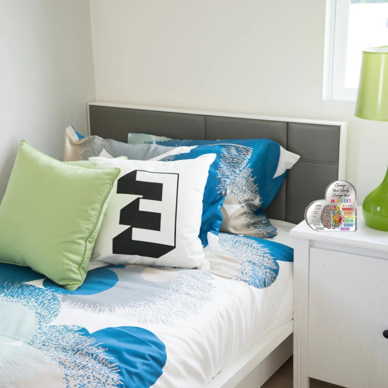 Bedroom with colorful bedding and pillows on a bed with a gray headboard.