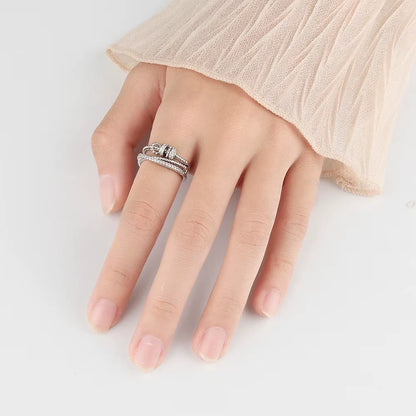 Hand wearing a silver ring on a light background