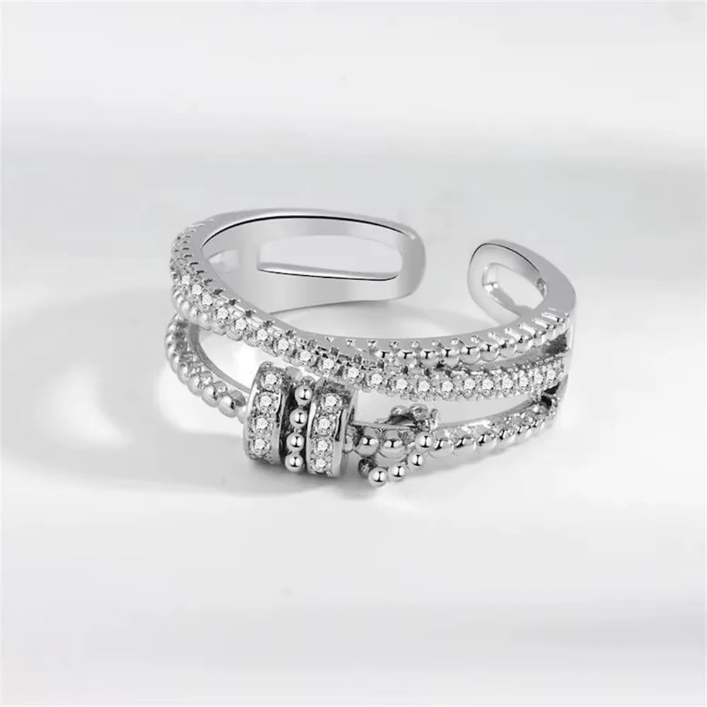 Silver ring with spinner accents on a light gray background