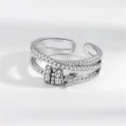 Silver ring with spinner accents on a light gray background