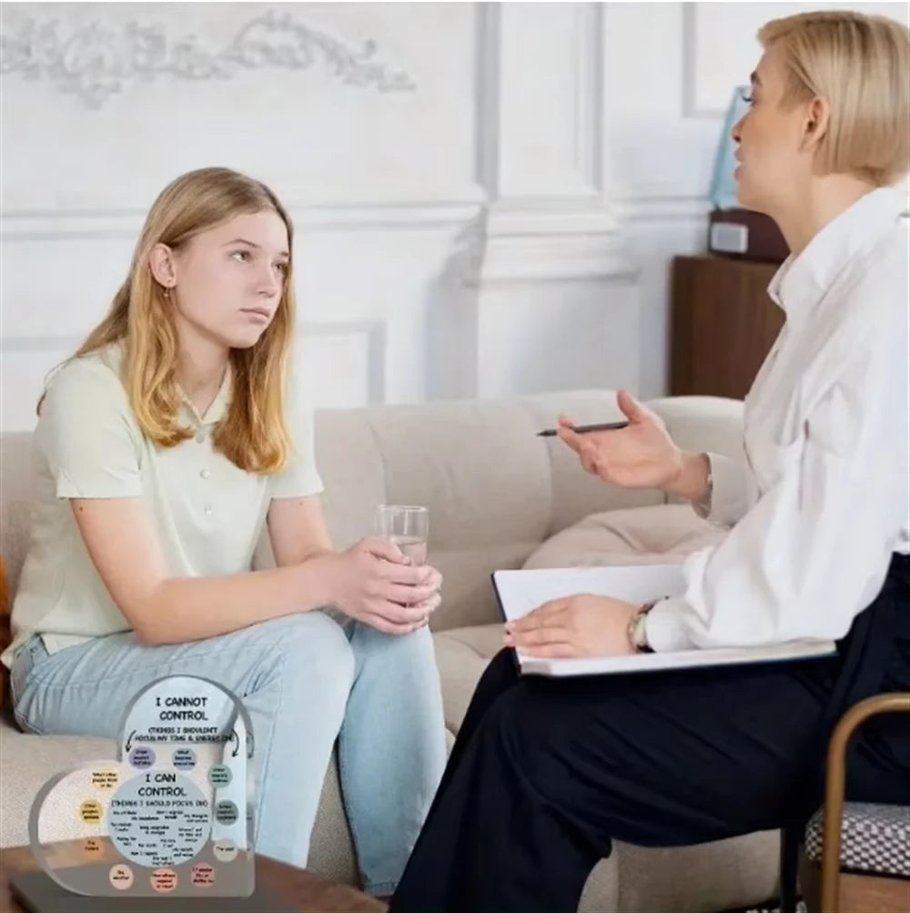Person sitting on a couch in a therapy session with a therapist, holding a card.